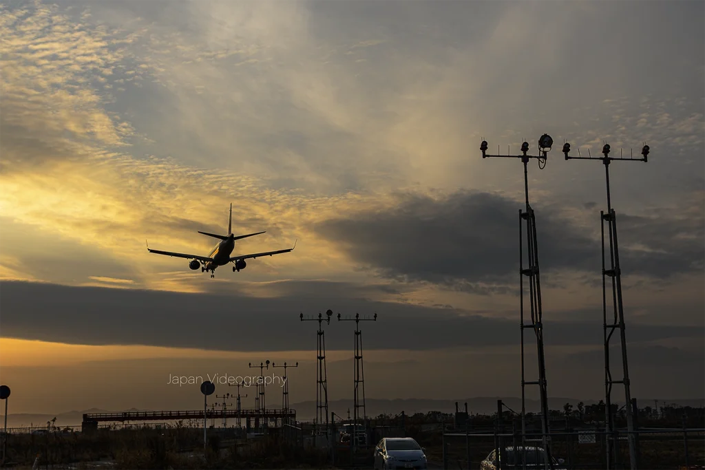 夕焼けが美しい仙台空港の進入灯と着陸機